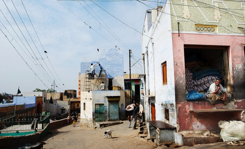 Illustrasjonsfoto: Livets teater spilles på gatene i India. Hver dag er en ny forestilling.

Et ordnet kaos av strømledninger bryter opp den blå himmelen. En av husveggene går i ett med skyene. På taket står to menn og stryker maling. Det kan se ut som de har blandet ut dagens himmelnyanser i lyseblått og hvitt. Til forveksling ligner det på malingen av teaterkulisser, men det er bare livets teater. Slik det spilles på gatene i India hver dag. Byen Bikaner i Rajastan er som indiske byer flest med et levende gateliv av absurditeter og fascinerende forestillinger.

Foto: Erlend Berge